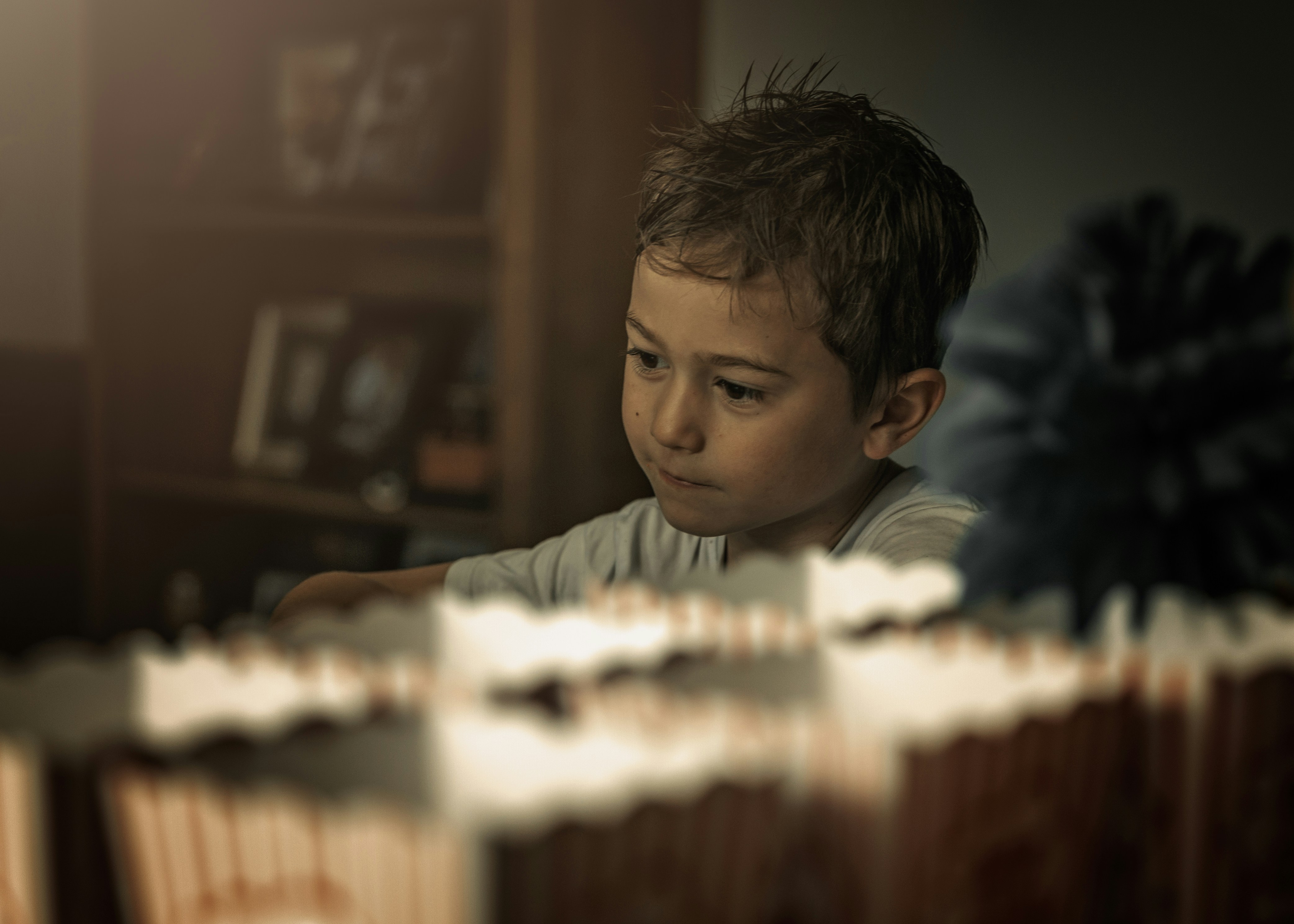 boy in gray crew neck shirt playing with white and red cake