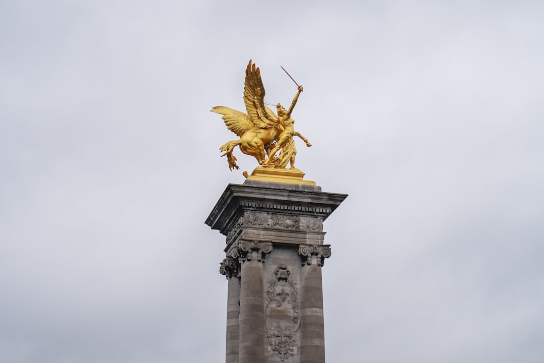 gold angel statue under white sky during daytime