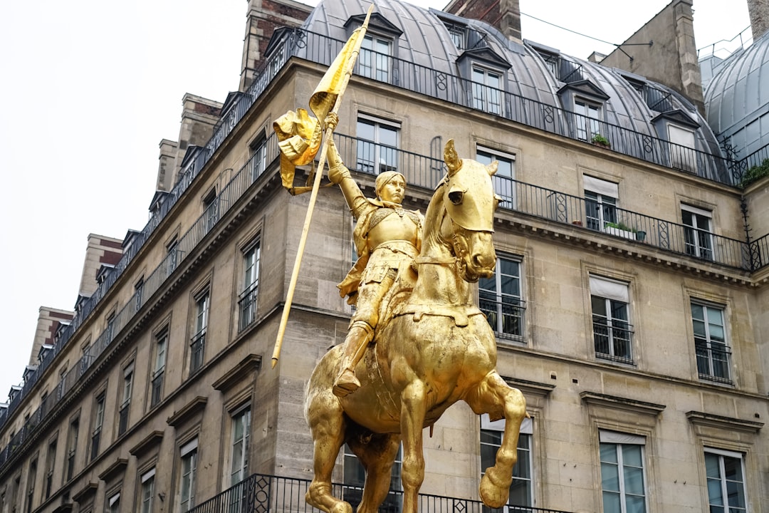 gold statue of man holding yellow cross