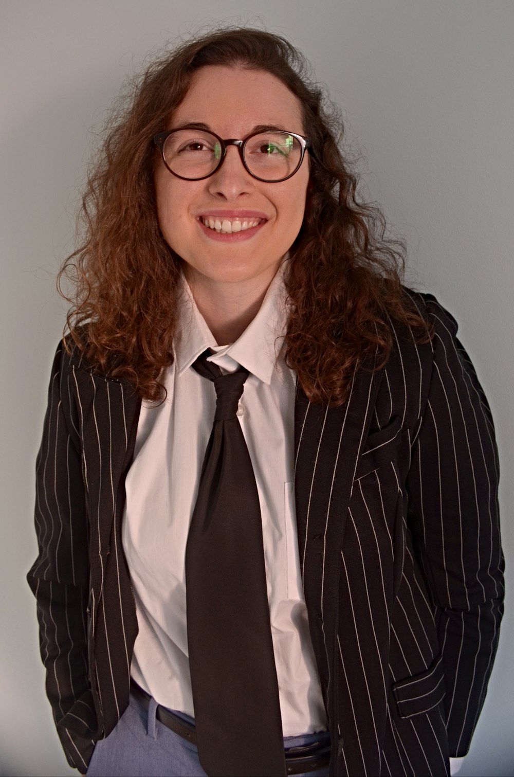 woman in black and white striped blazer wearing eyeglasses