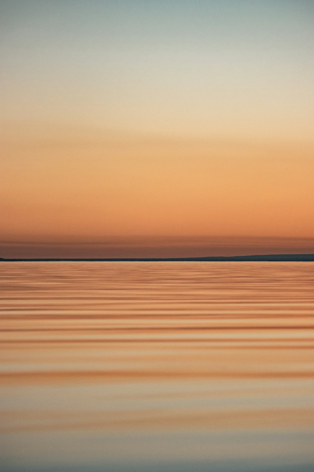 calm sea under orange sky during sunset