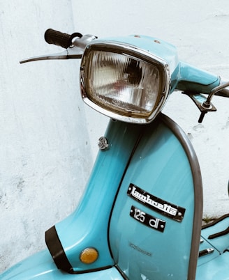 blue and silver motorcycle beside white wall
