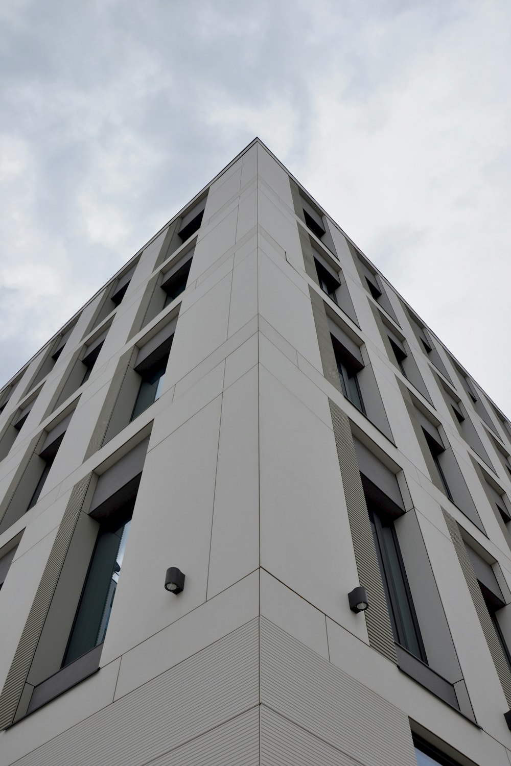 bâtiment en béton blanc sous des nuages blancs pendant la journée