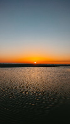 calm sea under orange sky during sunset