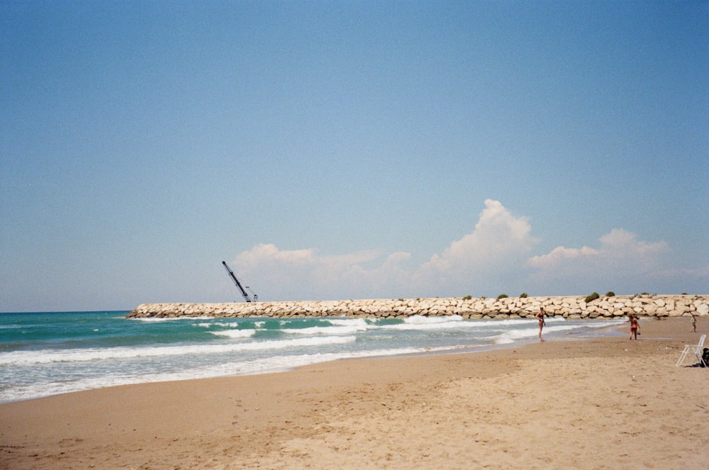 낮에는 푸른 하늘 아래 푸른 바닷물이 있는 갈색 모래 해변