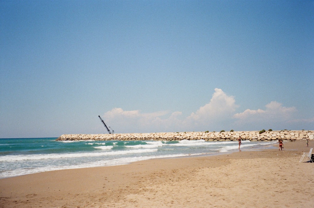 brown sand beach with blue ocean water under blue sky during daytime