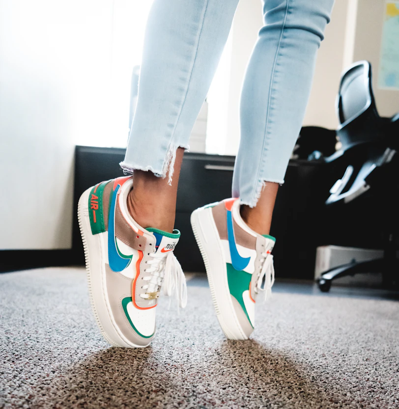 woman in black pants wearing red and black nike sneakers