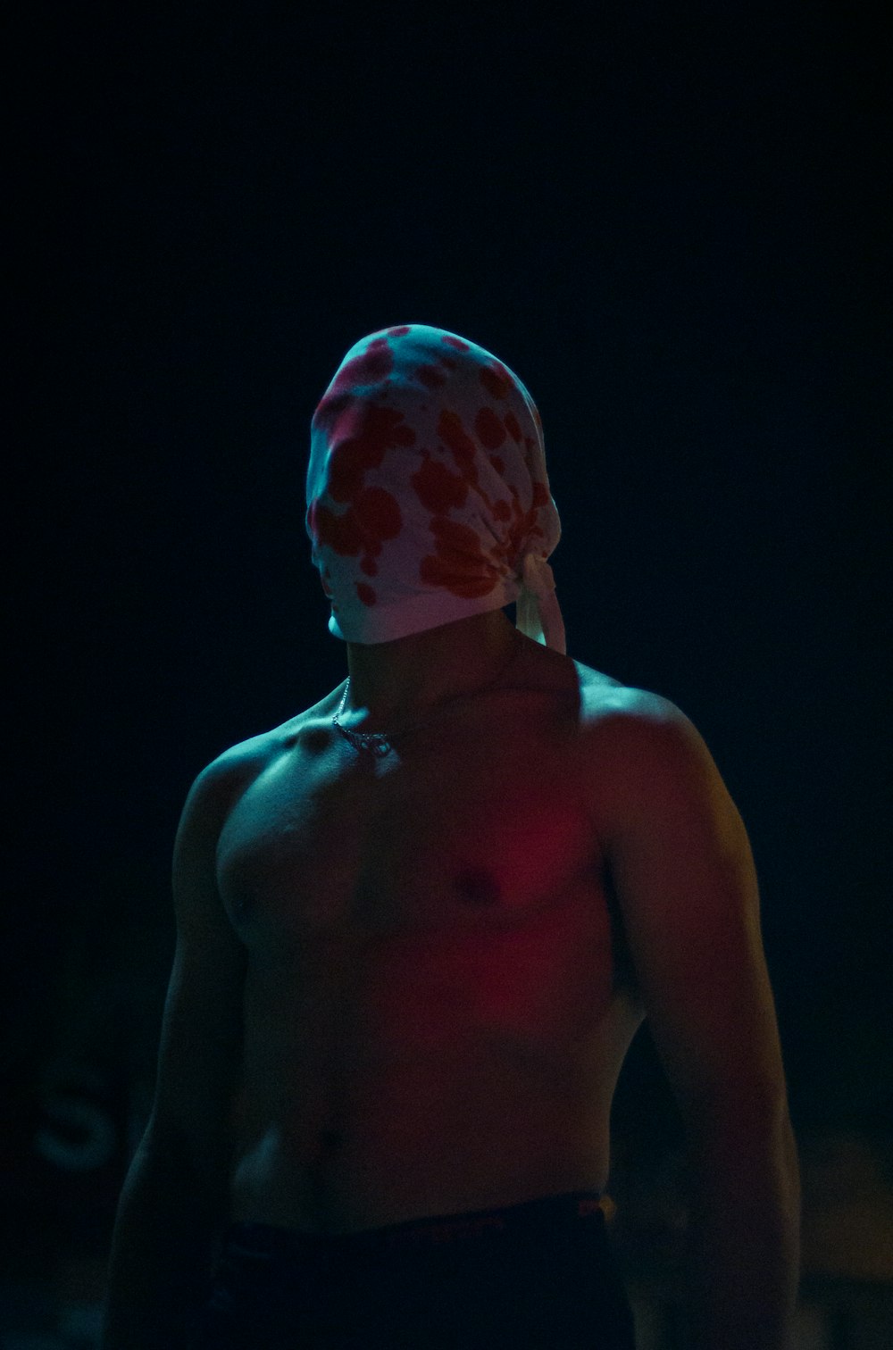 topless man with red and white bandana