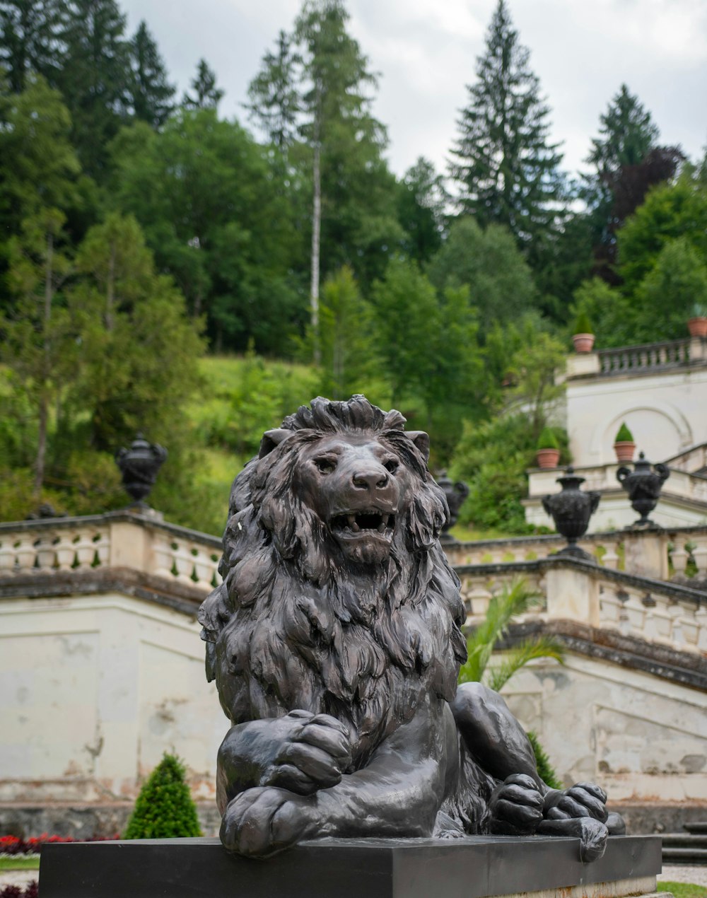 statue de lion en béton gris pendant la journée