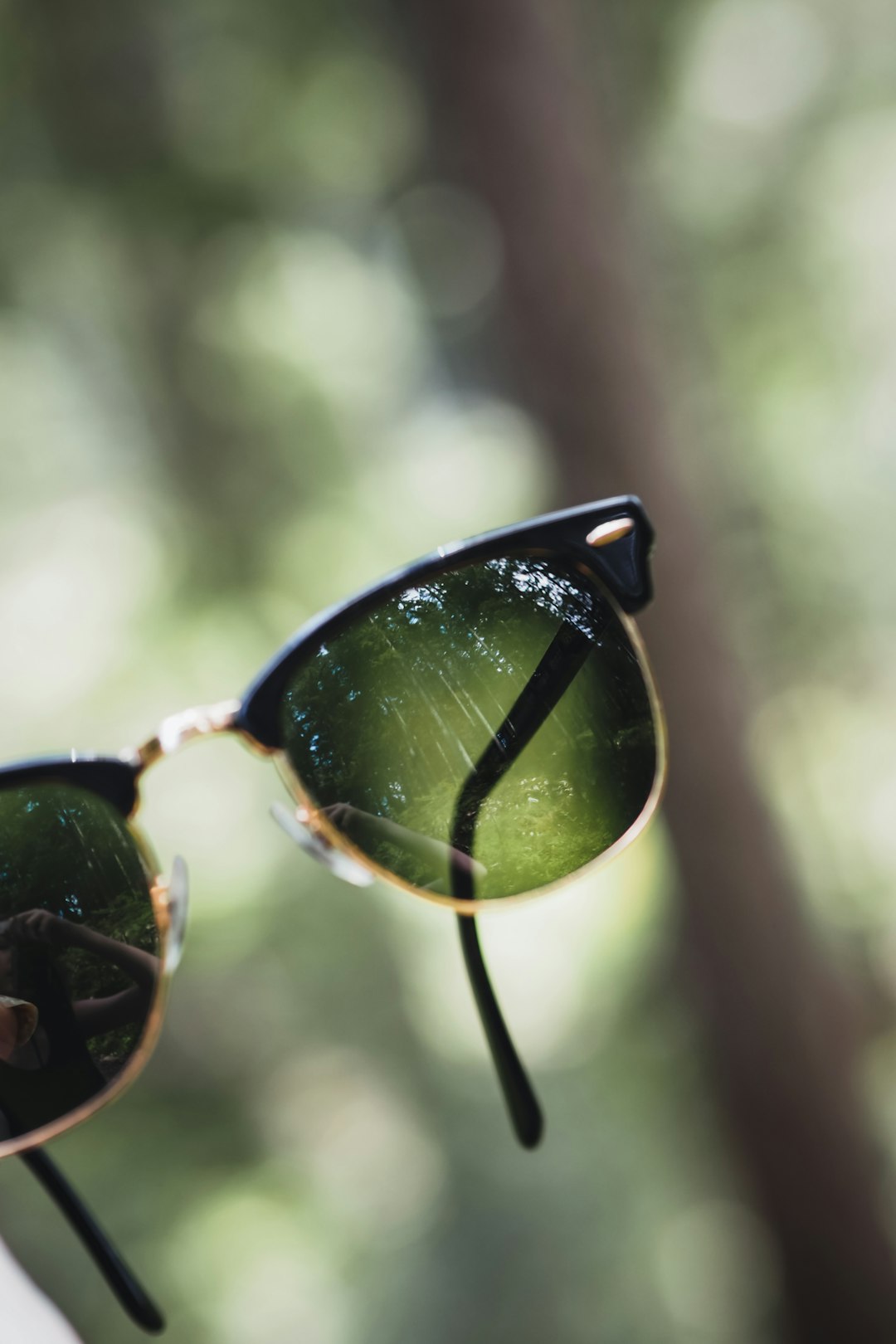 black framed sunglasses with green lens