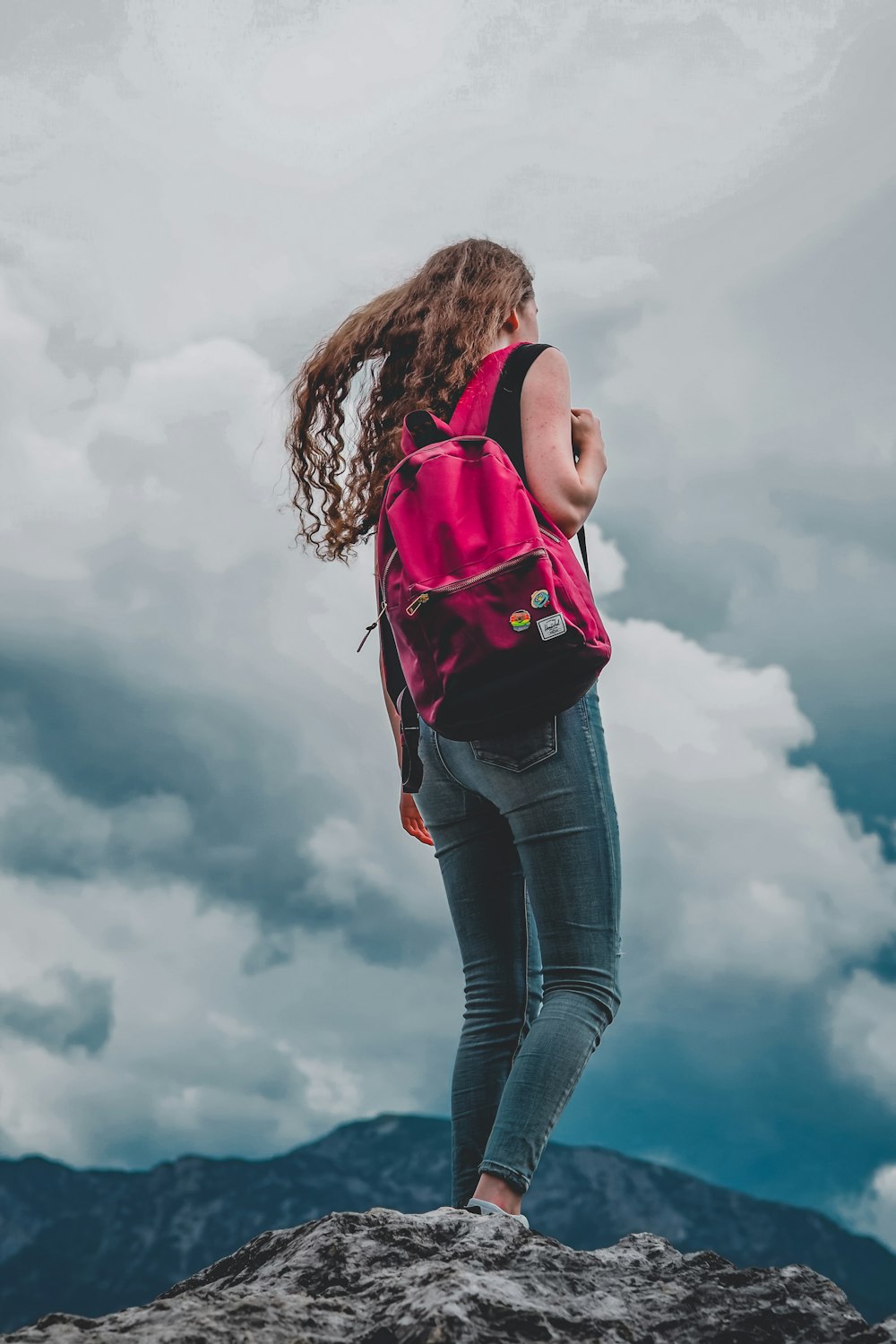 woman in pink tank top and blue denim jeans