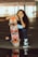 woman in blue tank top holding orange and black skateboard