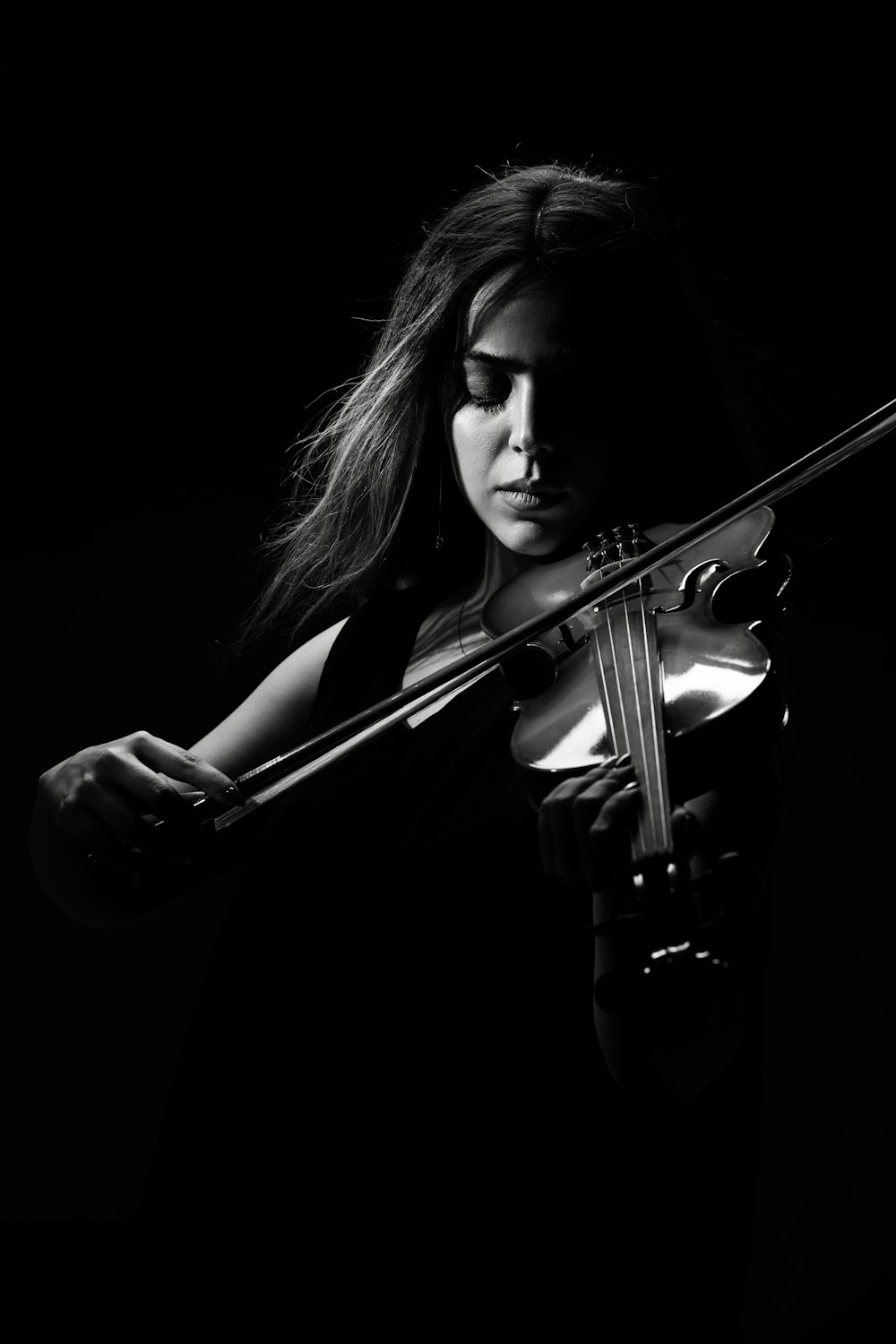 woman playing violin in grayscale photography