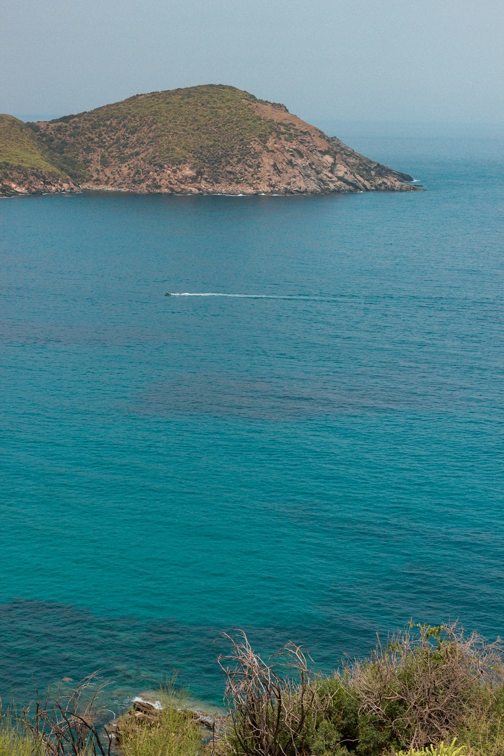 boat on sea near mountain during daytime