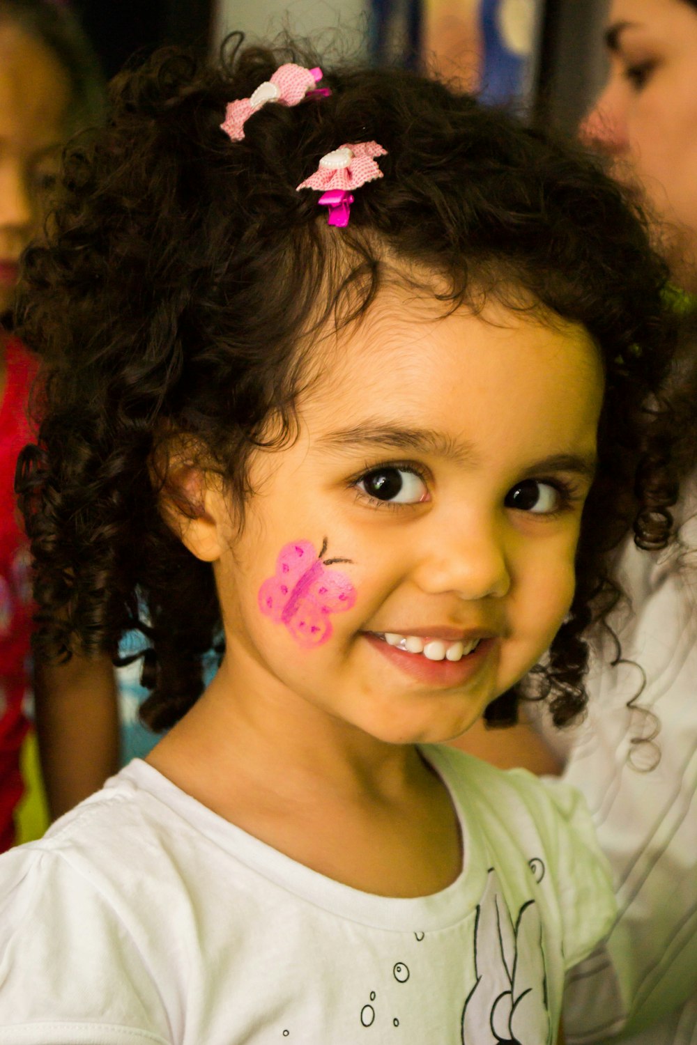 girl in white crew neck shirt with pink and white polka dots on her face