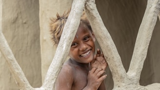 Child adjusting the height of the wooden easel with a smile.
