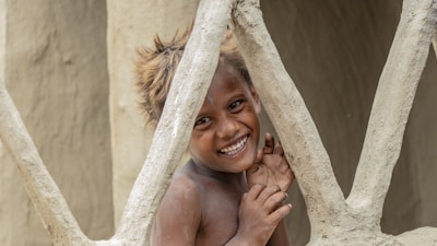 Child adjusting the height of the wooden easel with a smile.