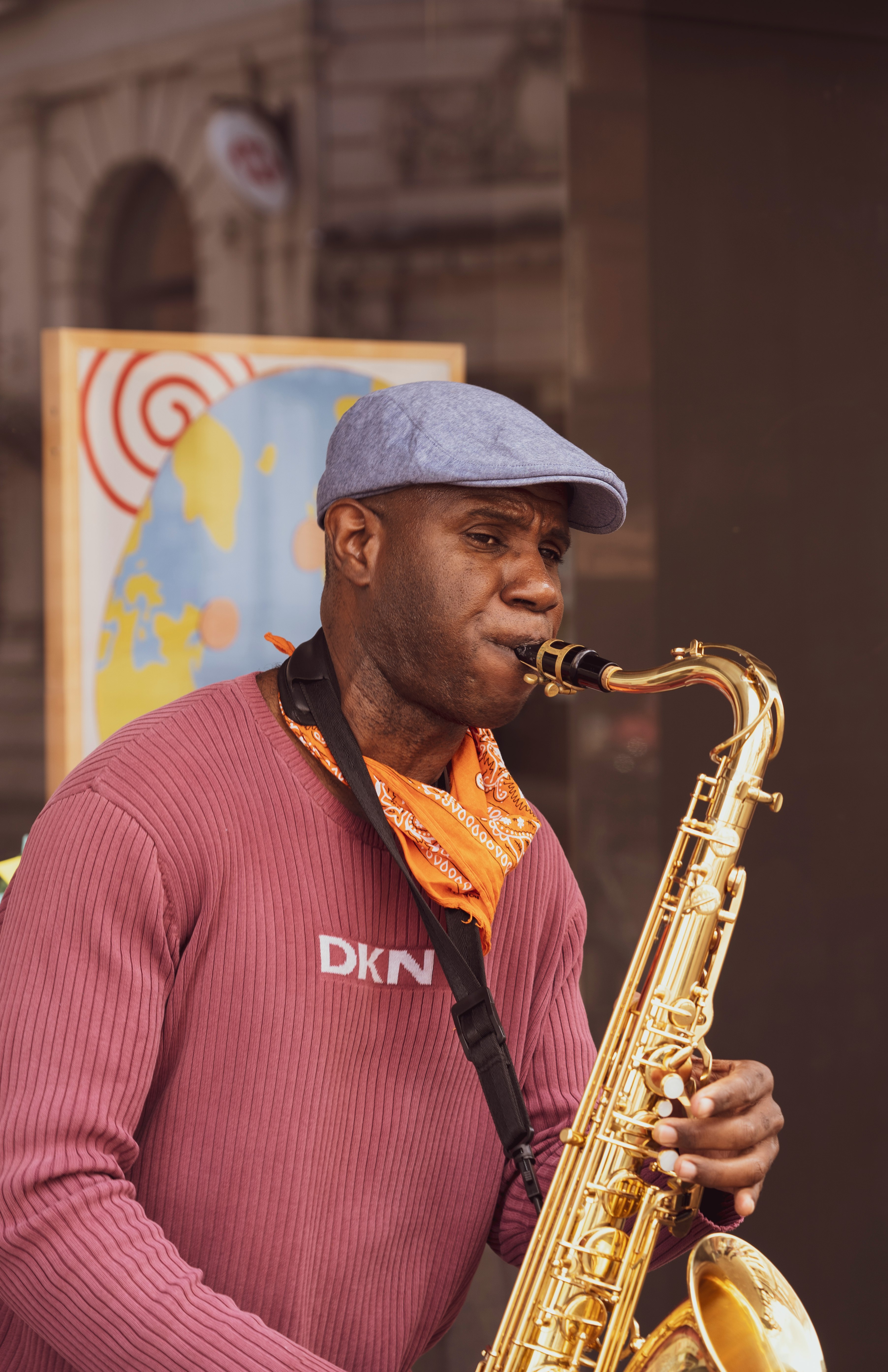 man in red and white striped polo shirt playing saxophone