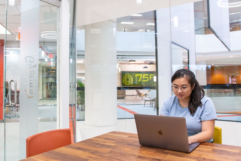 woman in black shirt using macbook