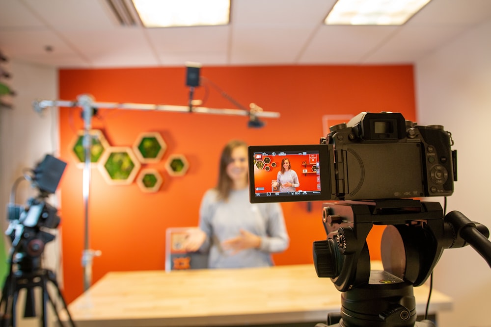 black video camera on brown wooden table