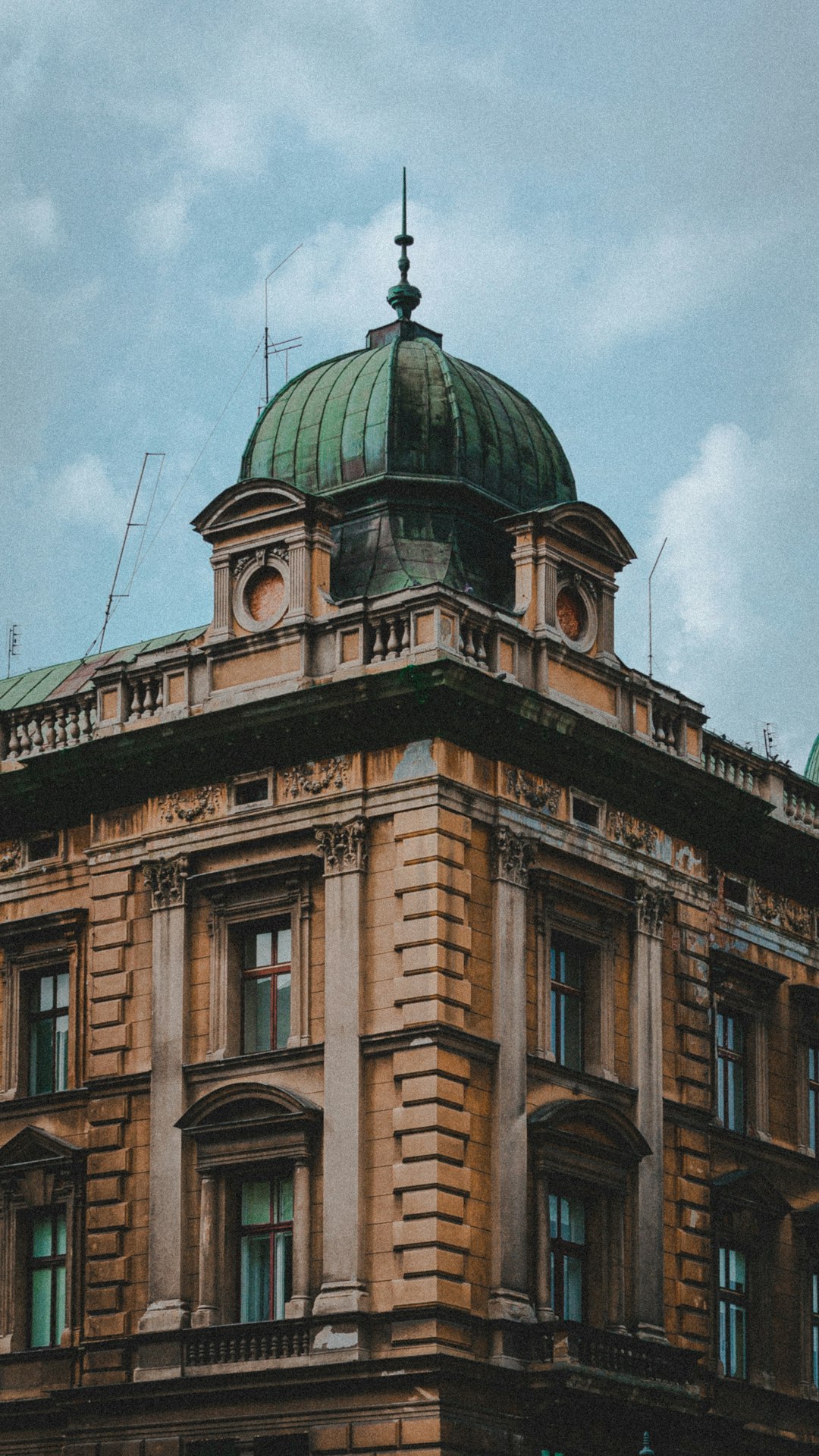 brown and green concrete building under white clouds during daytime