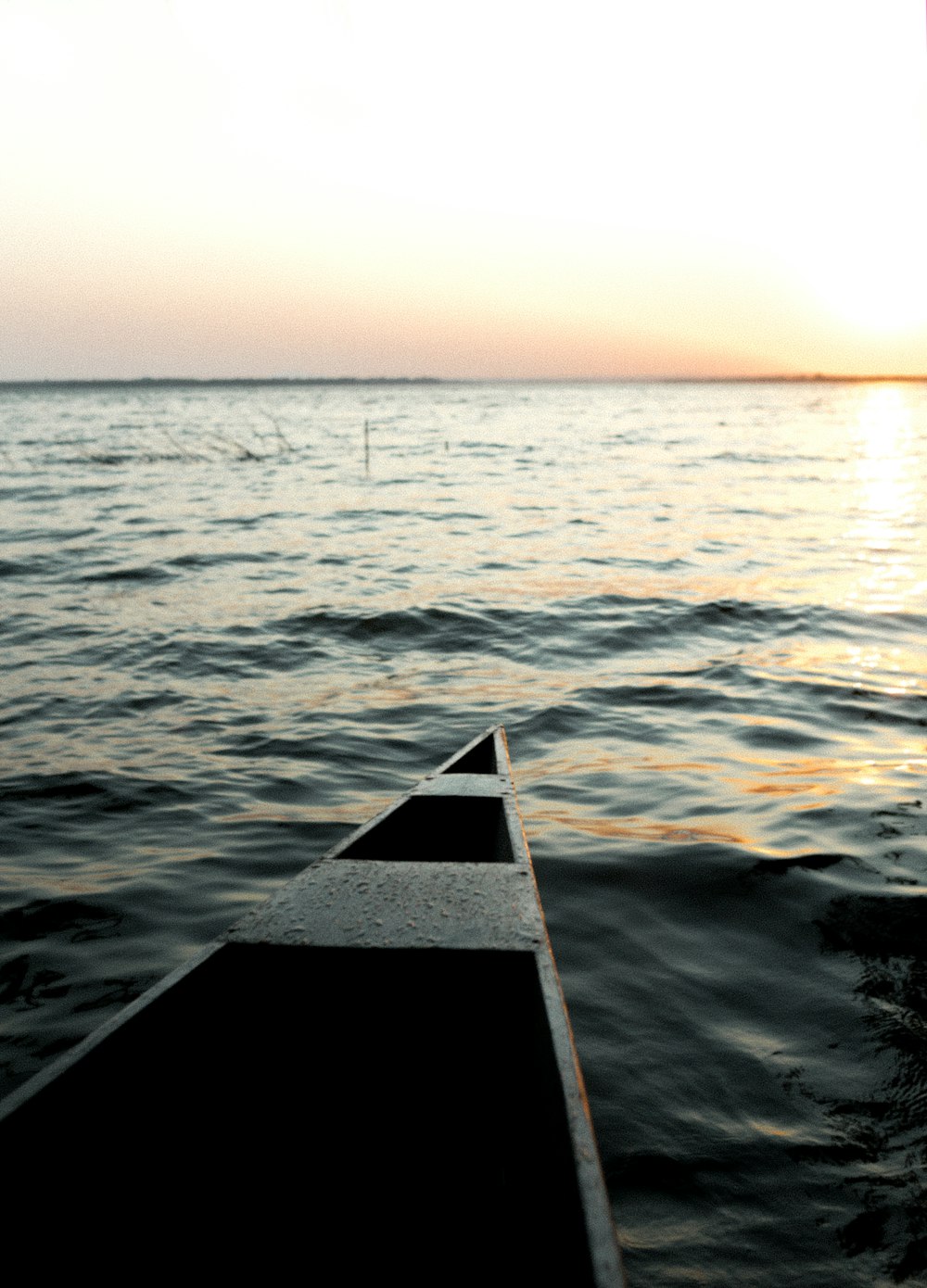 brown wooden dock on body of water during sunset