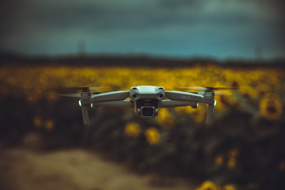 white drone flying over green grass field during daytime