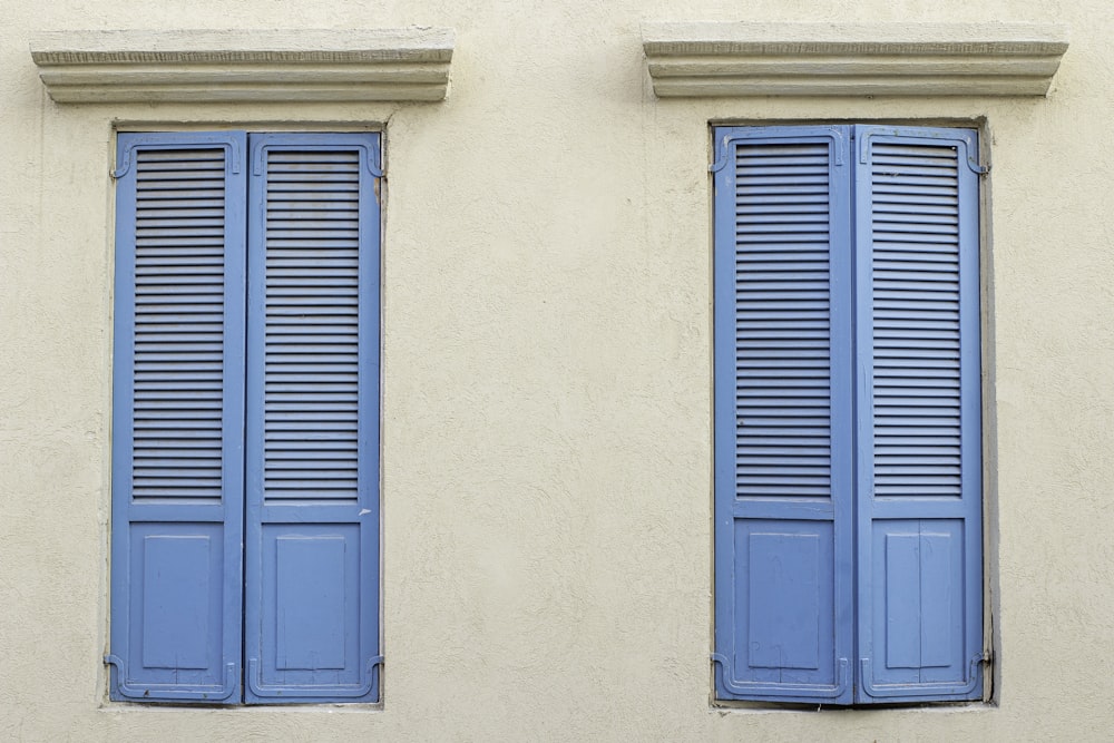 blue wooden door on white concrete wall