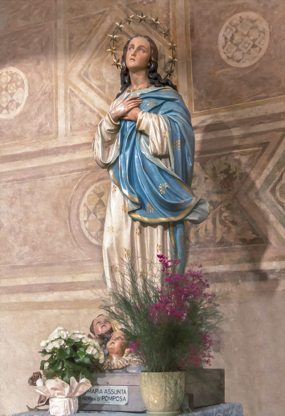 virgin mary statue beside pink flowers