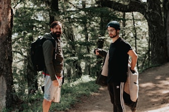 man in black jacket and white shorts standing beside woman in black jacket