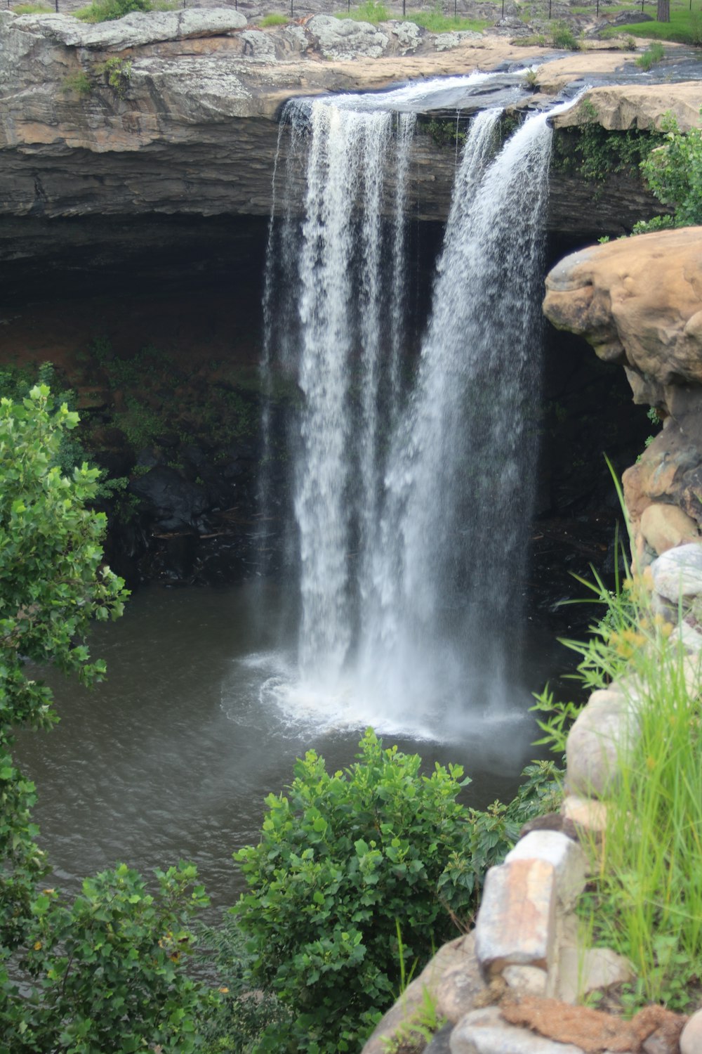 water falls in the middle of brown rocks