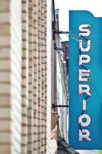 a blue sign hanging from the side of a building