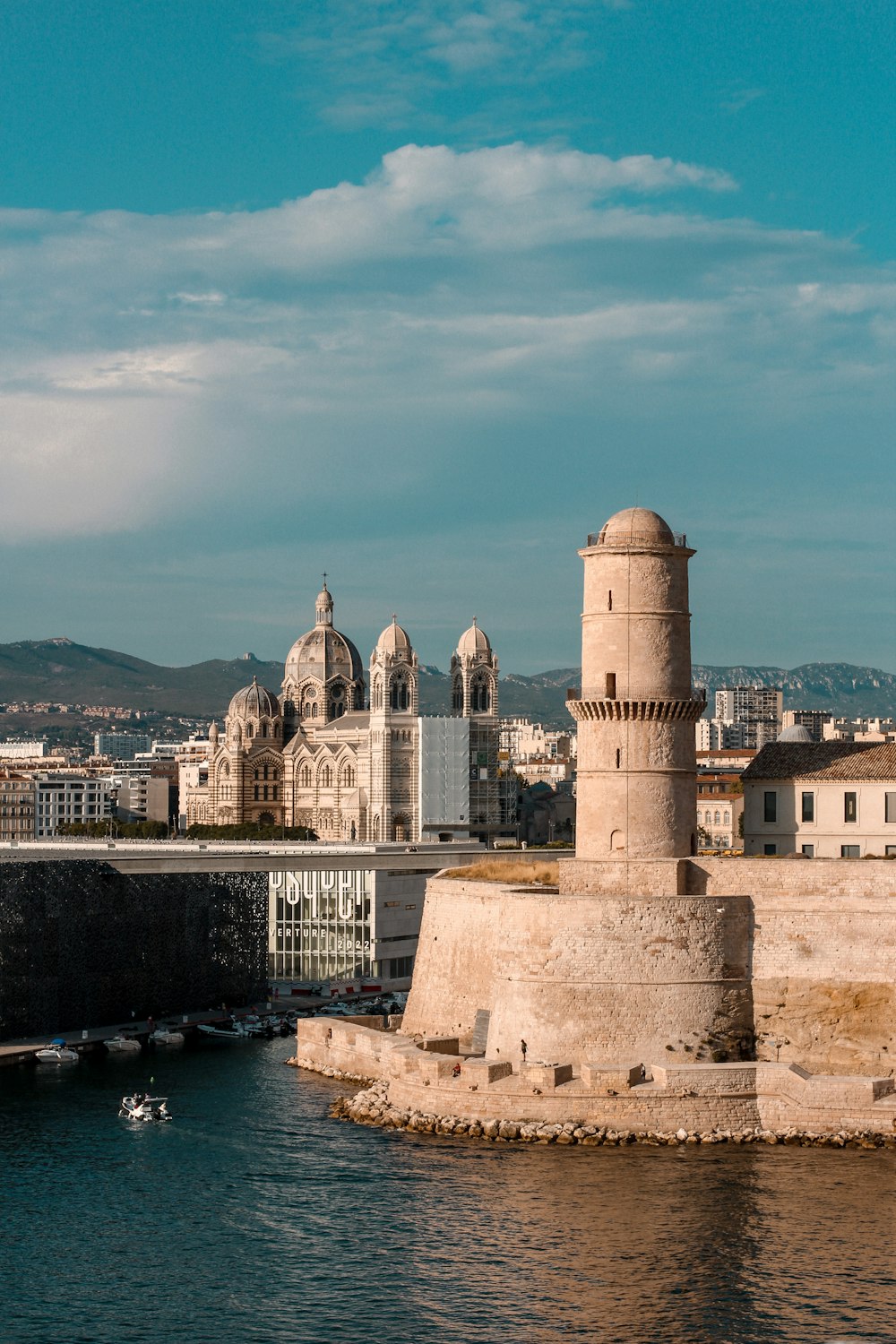 edificio in cemento bianco vicino a uno specchio d'acqua durante il giorno