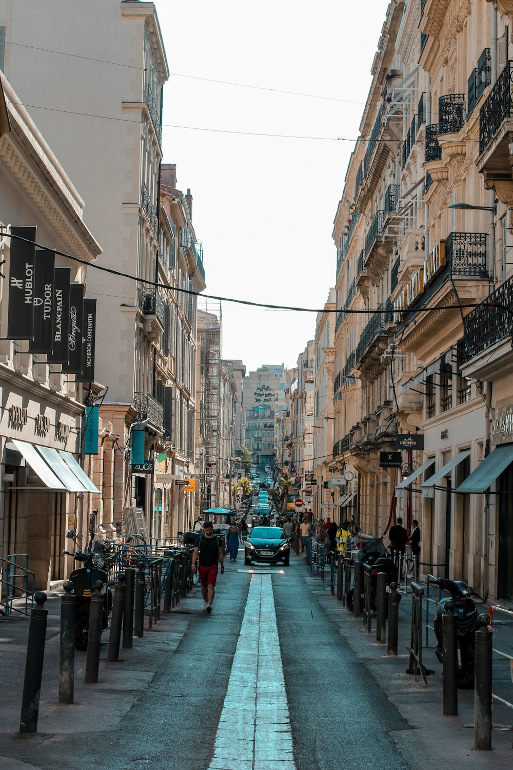 persone che camminano per strada tra gli edifici durante il giorno