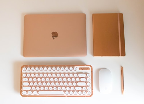 Flat lay of elegant digital tools and notebooks with gold accents.