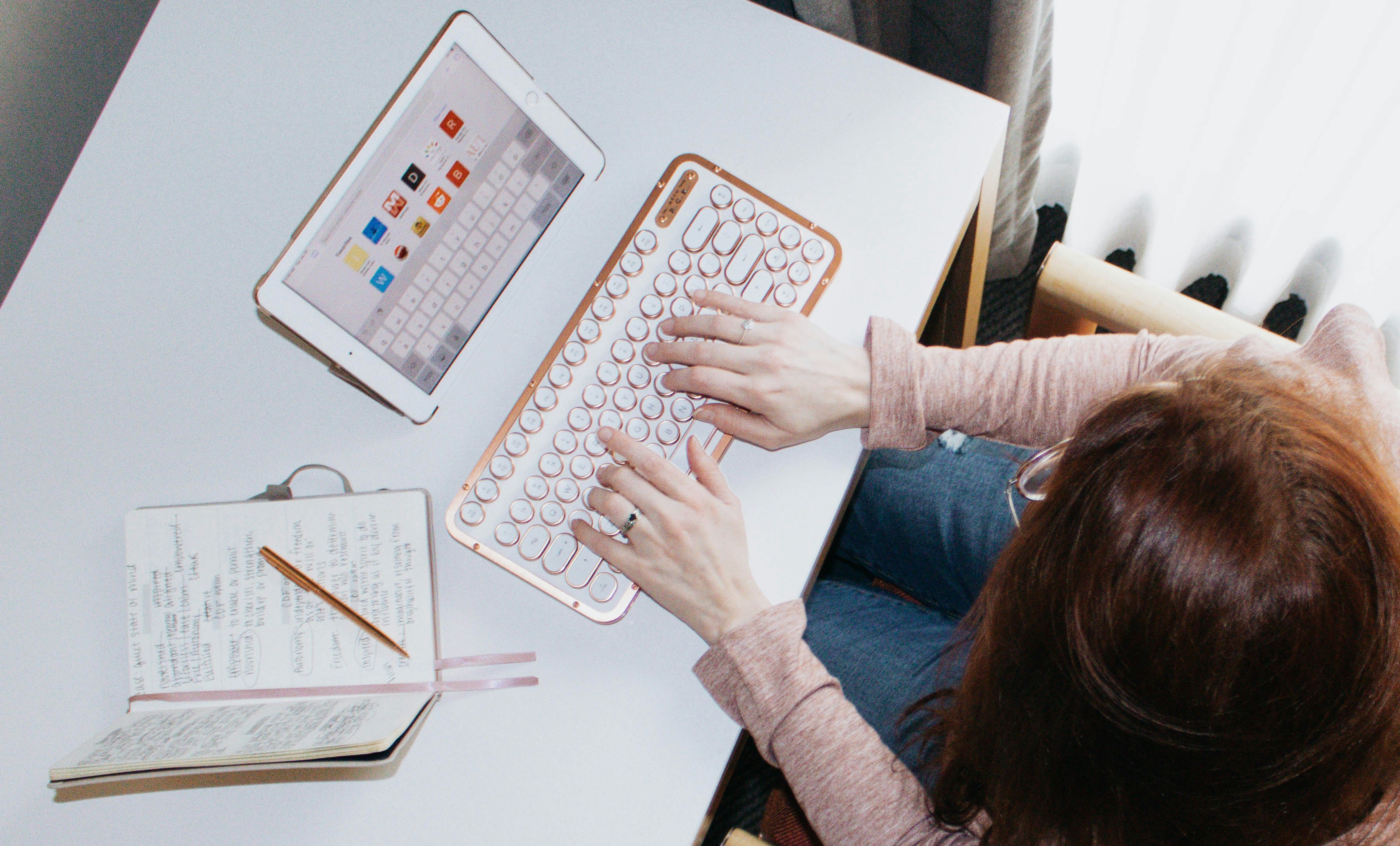 Persona en camisa azul de manga larga con teclado de computadora blanco