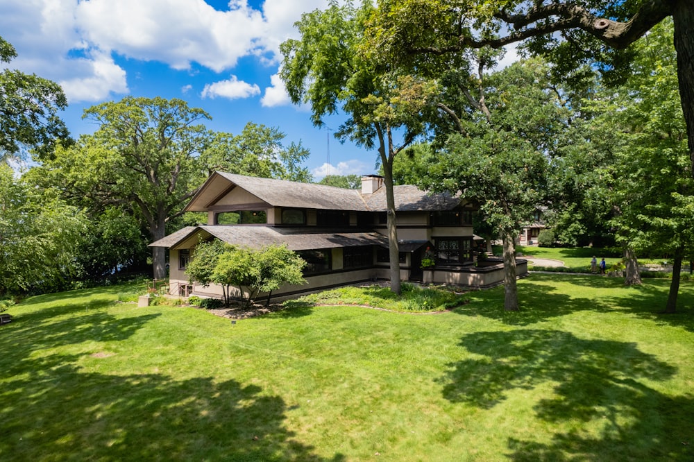 brown wooden house near green trees under blue sky during daytime