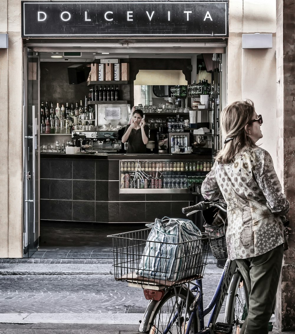 woman in white and brown long sleeve shirt and blue denim jeans holding shopping cart