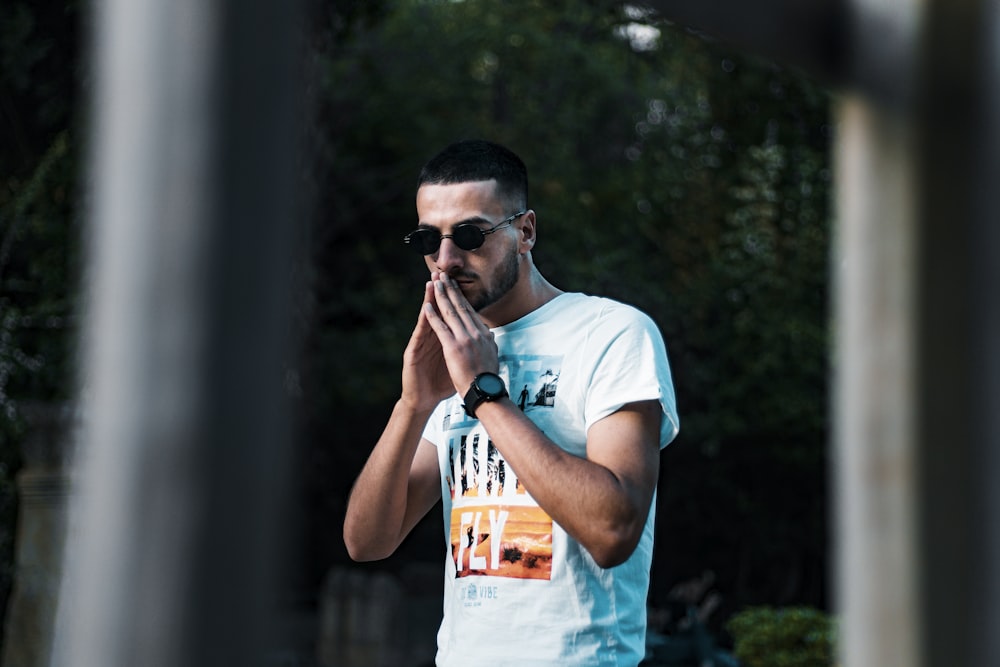 man in white crew neck t-shirt wearing black sunglasses