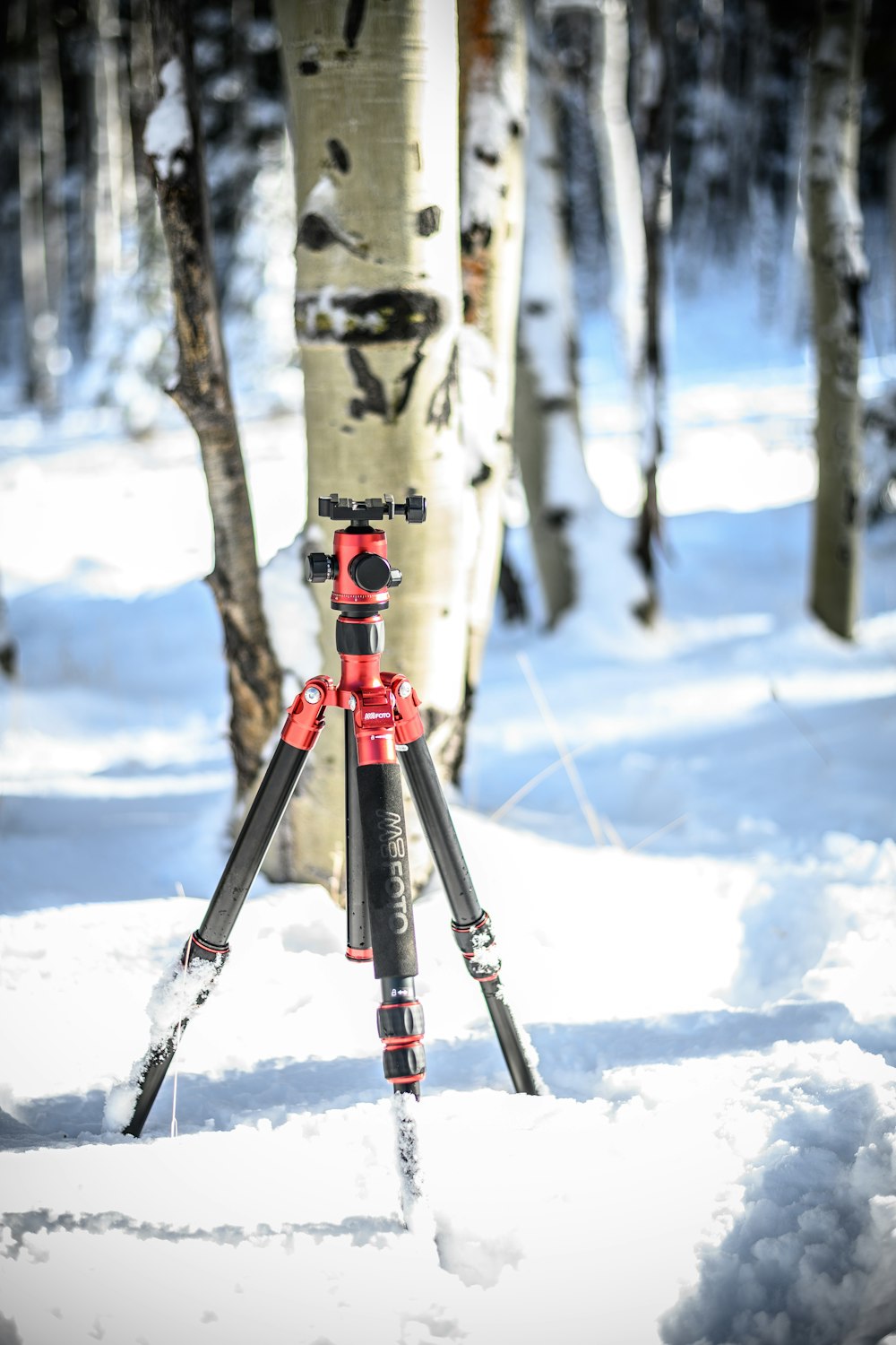 black and red tripod on snow covered ground during daytime