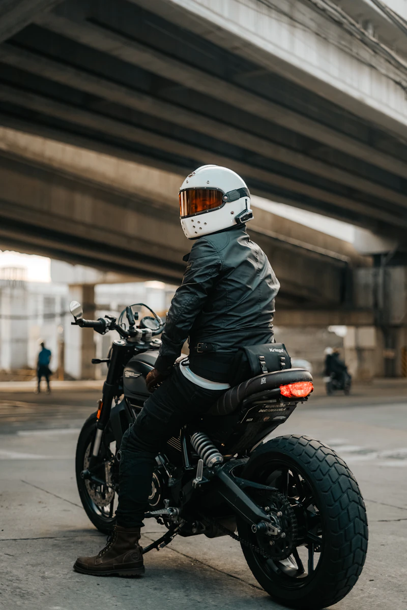 Rider in full gear standing with a motorcycle