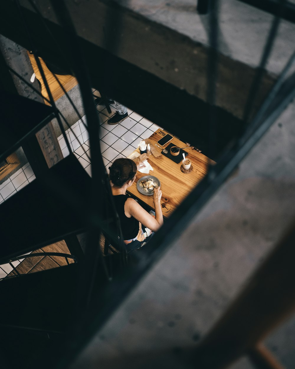 woman in black tank top sitting on brown wooden bench