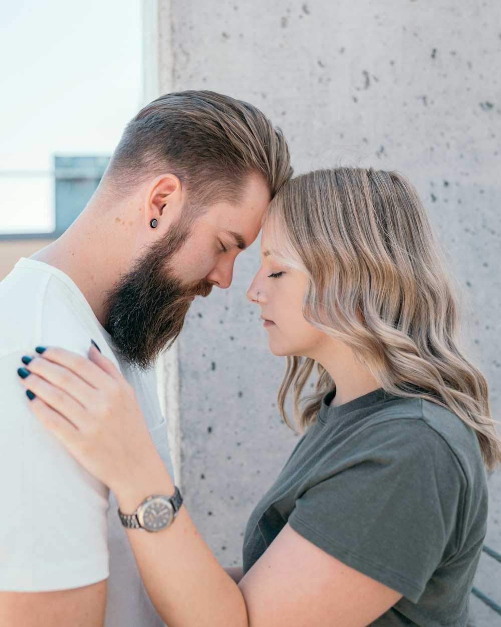 man in black crew neck t-shirt kissing woman in white long sleeve shirt