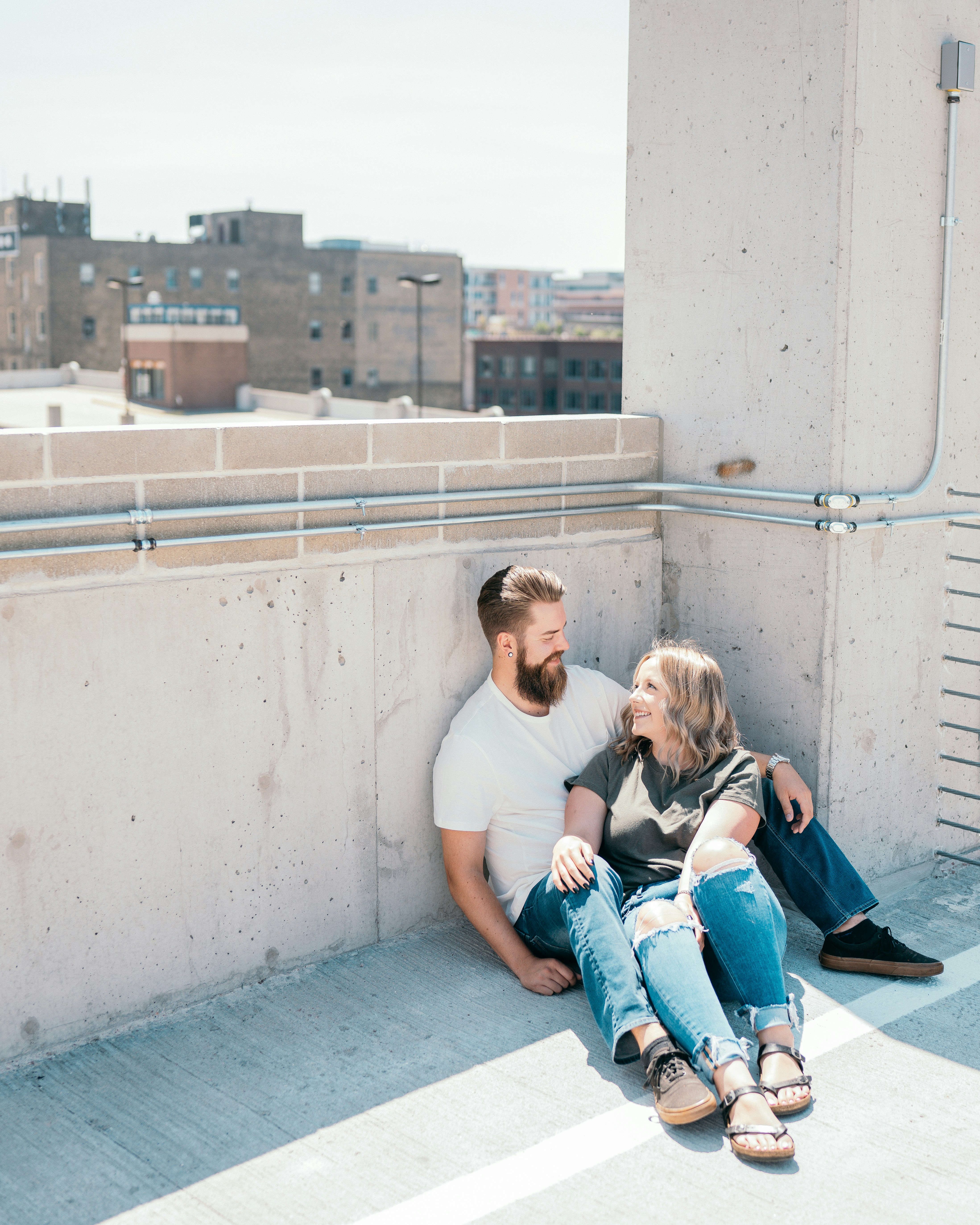 man and woman sitting on concrete wall during daytime