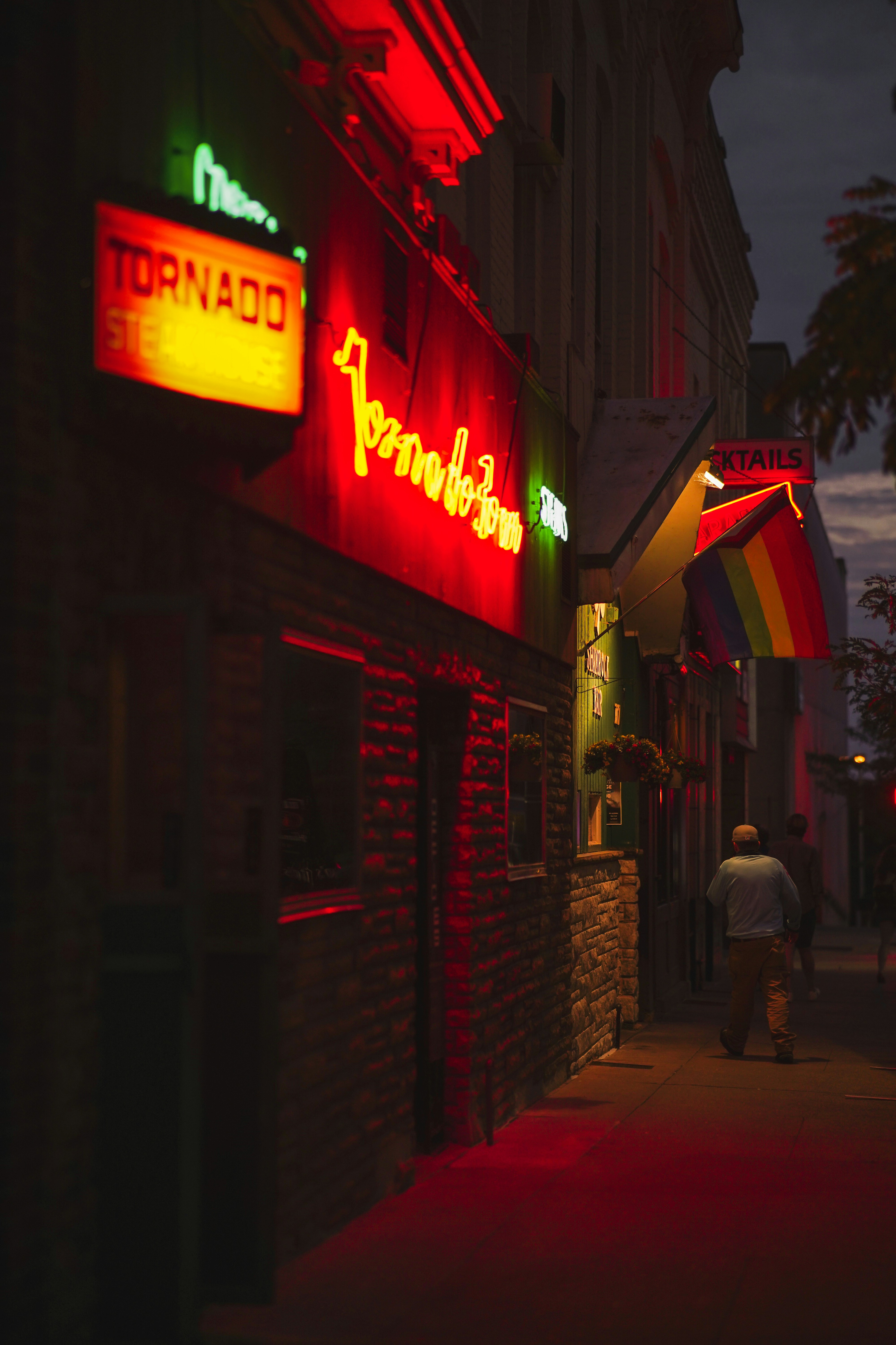 Man walking down the street in front of a strip of bars in Madison, Wisconsin.