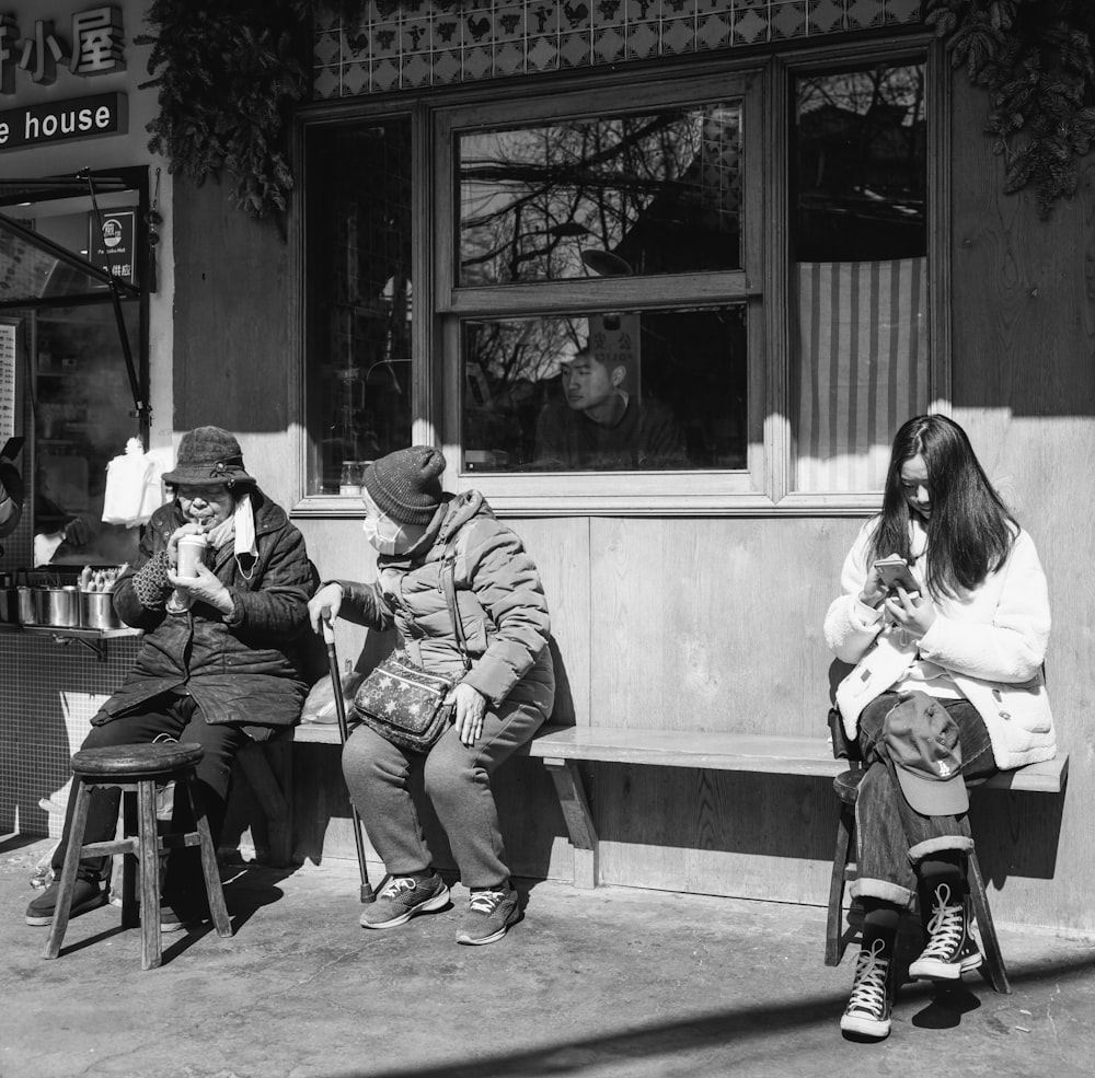 grayscale photo of 2 women sitting on bench