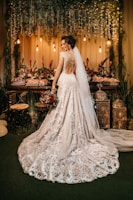 woman in white wedding dress standing beside red roses