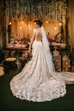 woman in white wedding dress standing beside red roses