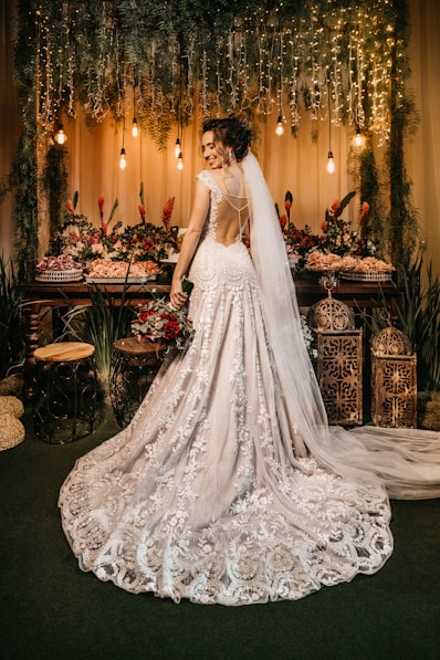 woman in white wedding dress standing beside red roses