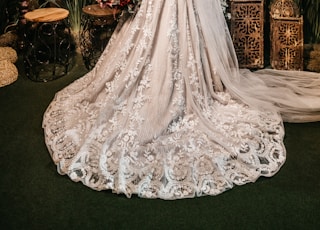 woman in white wedding dress standing beside red roses